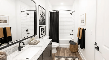 A bathroom with a white sink and black and white tiles.